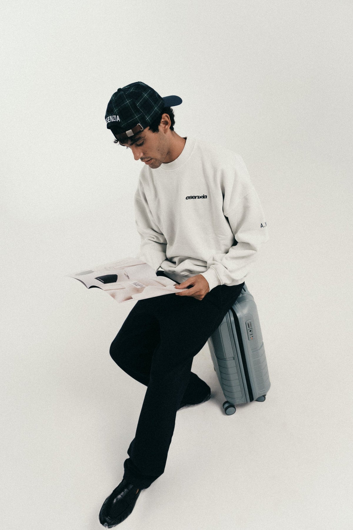 Esenzia Worldwide · lookbook · crewneck crema y maleta