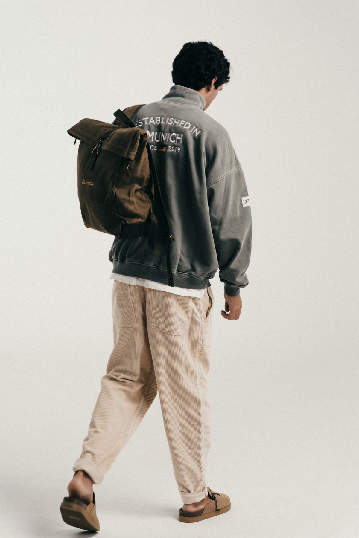Esenzia Worldwide · lookbook · half-zip gris y mochila